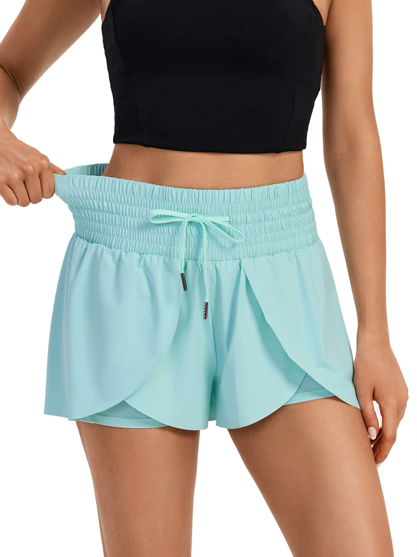 Model showcasing 2-in-1 high-waisted flowy athletic shorts in light blue, emphasizing stylish design and comfort.