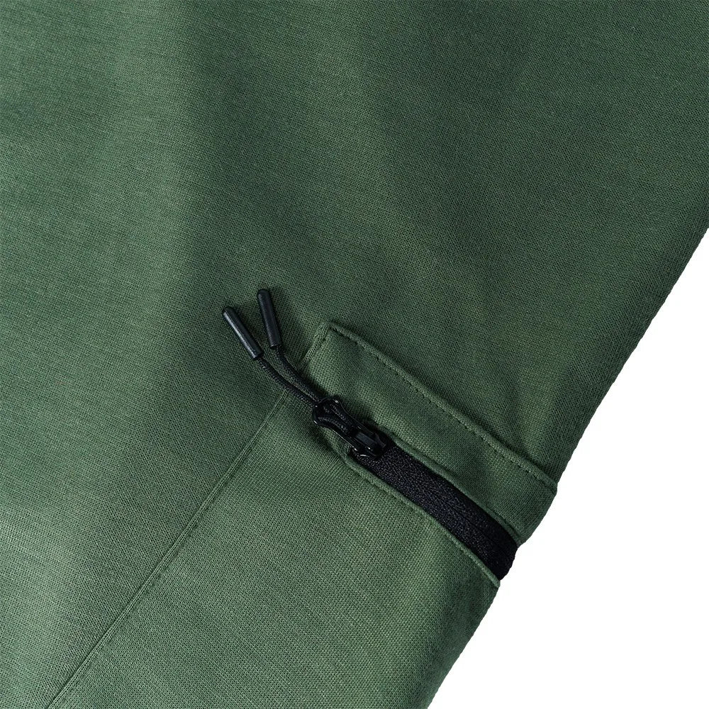 Close-up of green fleece-lined joggers featuring a zipper pocket and slim fit design for comfort and style.