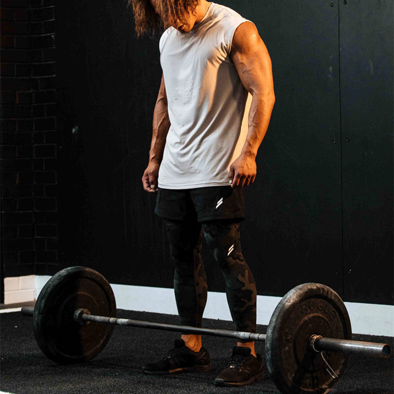 Muscular athlete in summer fitness tank top preparing to lift weights in a gym setting.