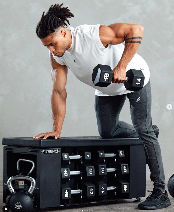 Man performing a dumbbell workout on a FITBENCH showcasing fitness and strength training.