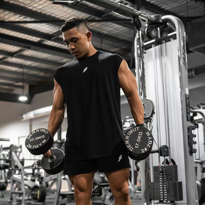 Man lifting weights in a gym wearing a black summer fitness sports tank top for workouts.