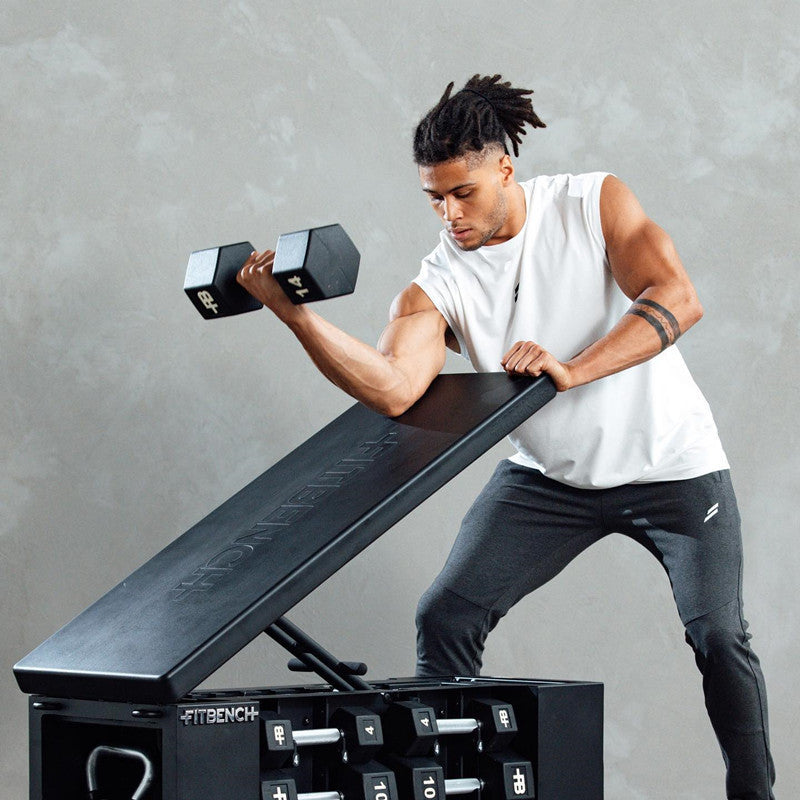 Man lifting dumbbells on a workout bench, showcasing the Summer Fitness Sports Tank Top during strength training.