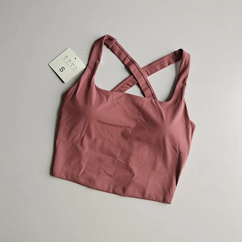 Seamless push-up sports bra for women in soft rose color, featuring crisscross straps for stylish support.