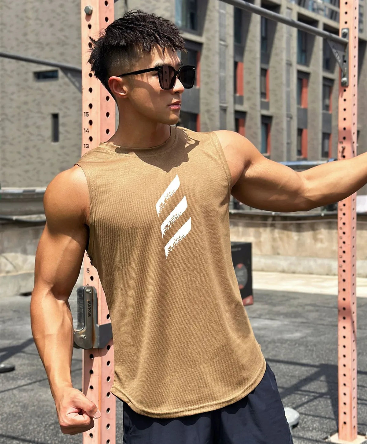 Muscular man in a brown sleeveless gym tank top, showcasing a stylish design for summer workouts.
