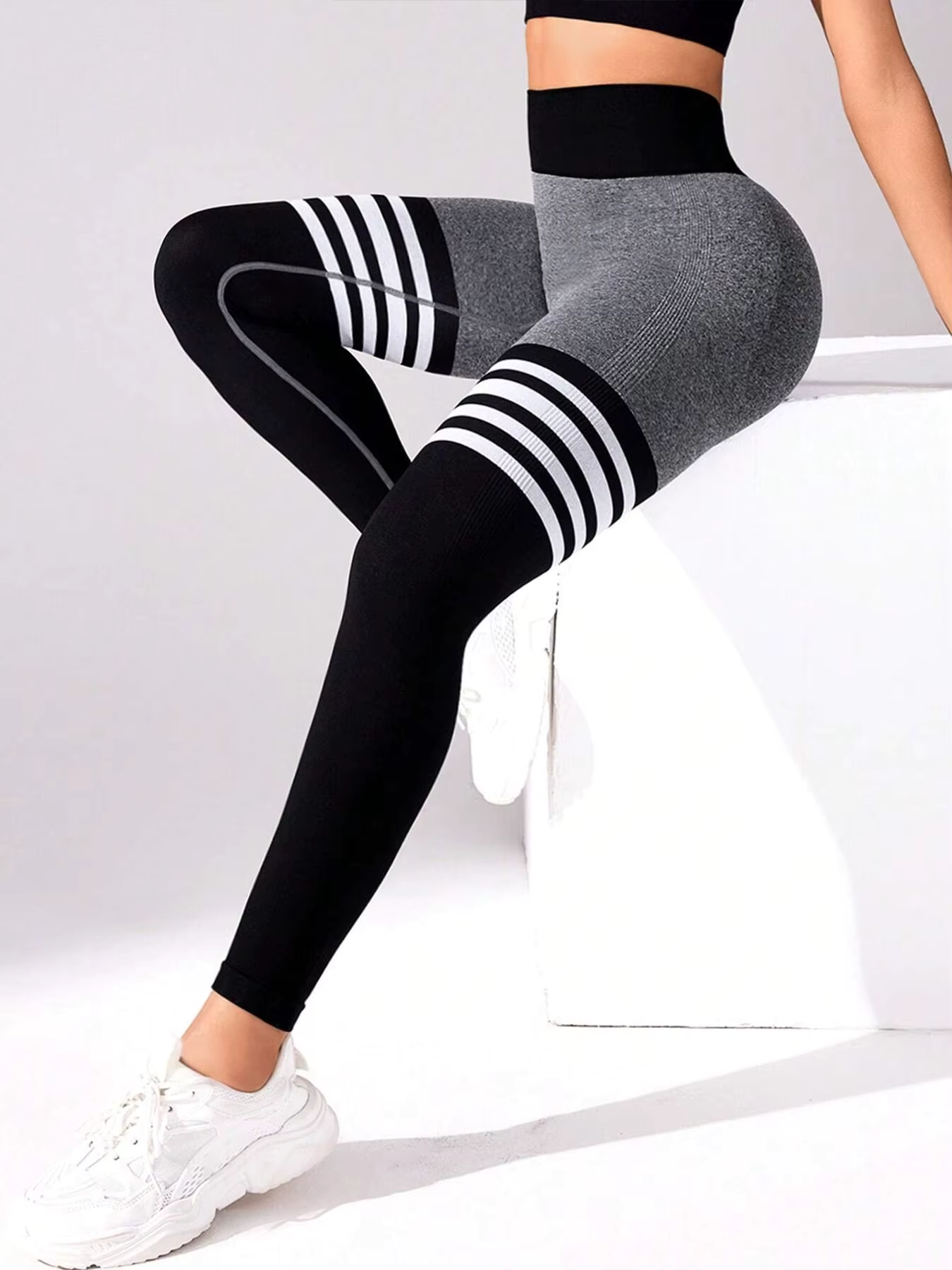 Women’s striped high-waist compression leggings in black and gray, ideal for stylish workouts and active days.