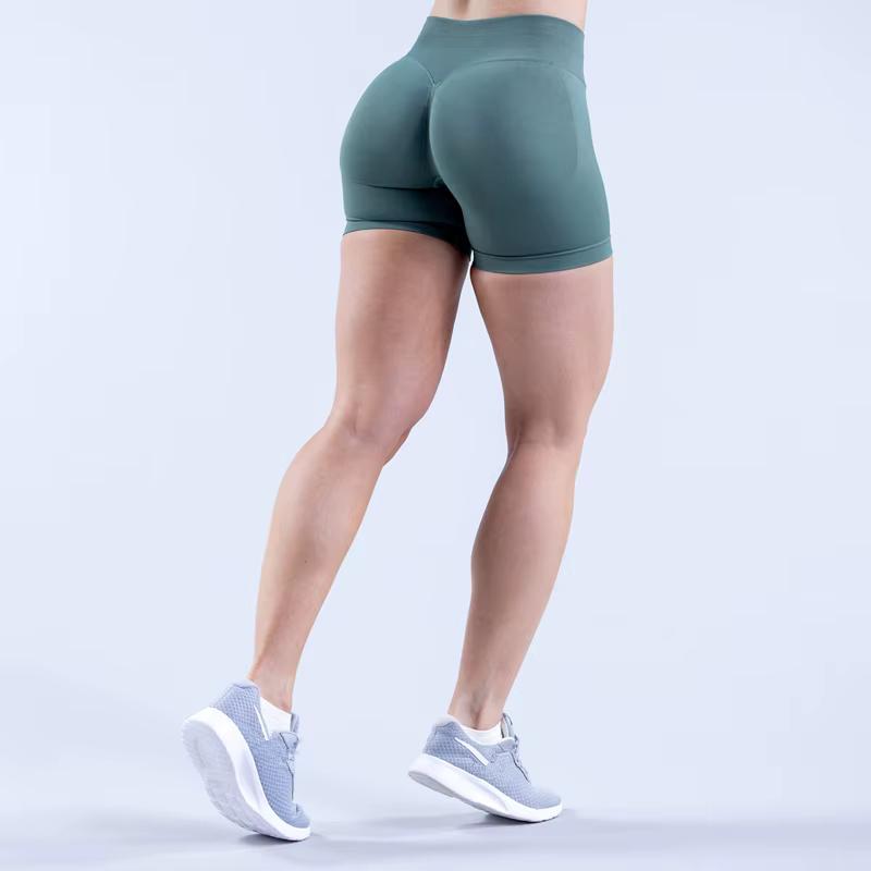 Rear view of a person wearing green Gym Impact Running Shorts and grey athletic shoes, showcasing comfort and style for workouts.
