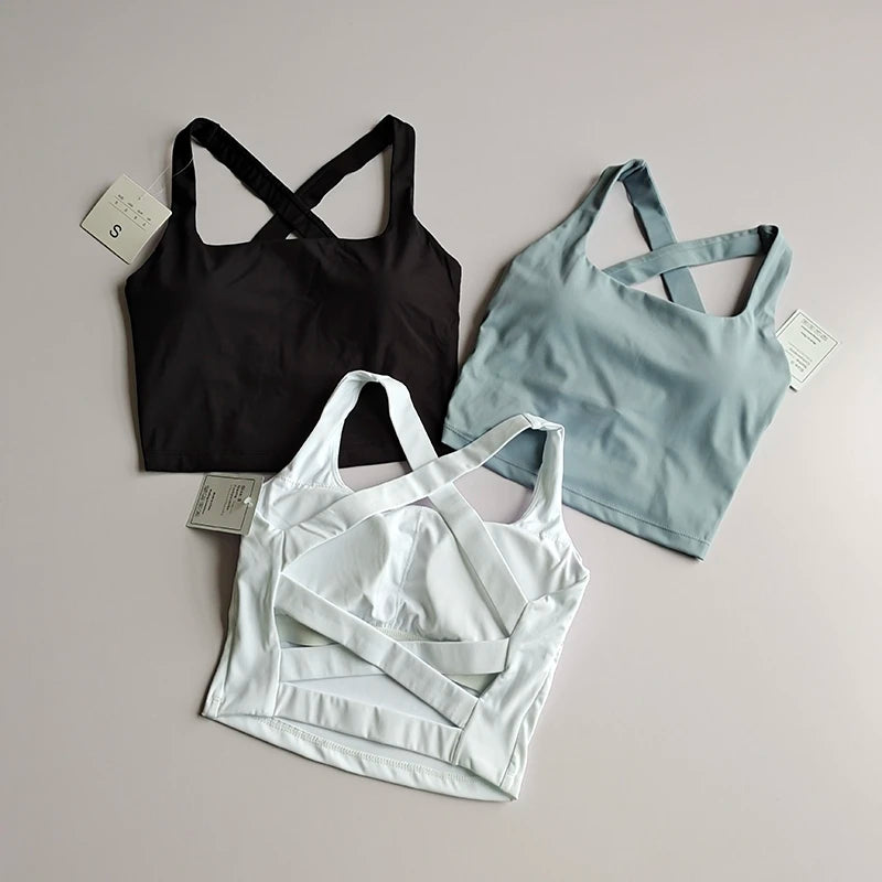 Three seamless push-up sports bras for women in black, light blue, and white, showcasing stylish crisscross designs.