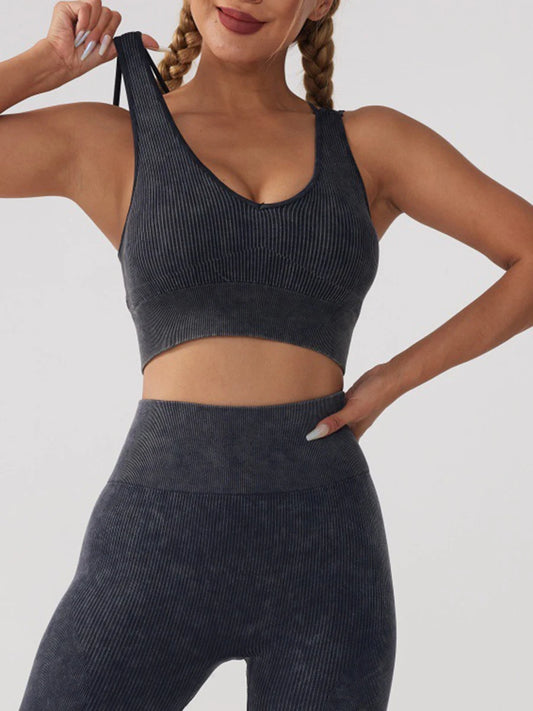 Woman wearing a dark grey ribbed high-impact racerback sports bra for optimal support during workouts.