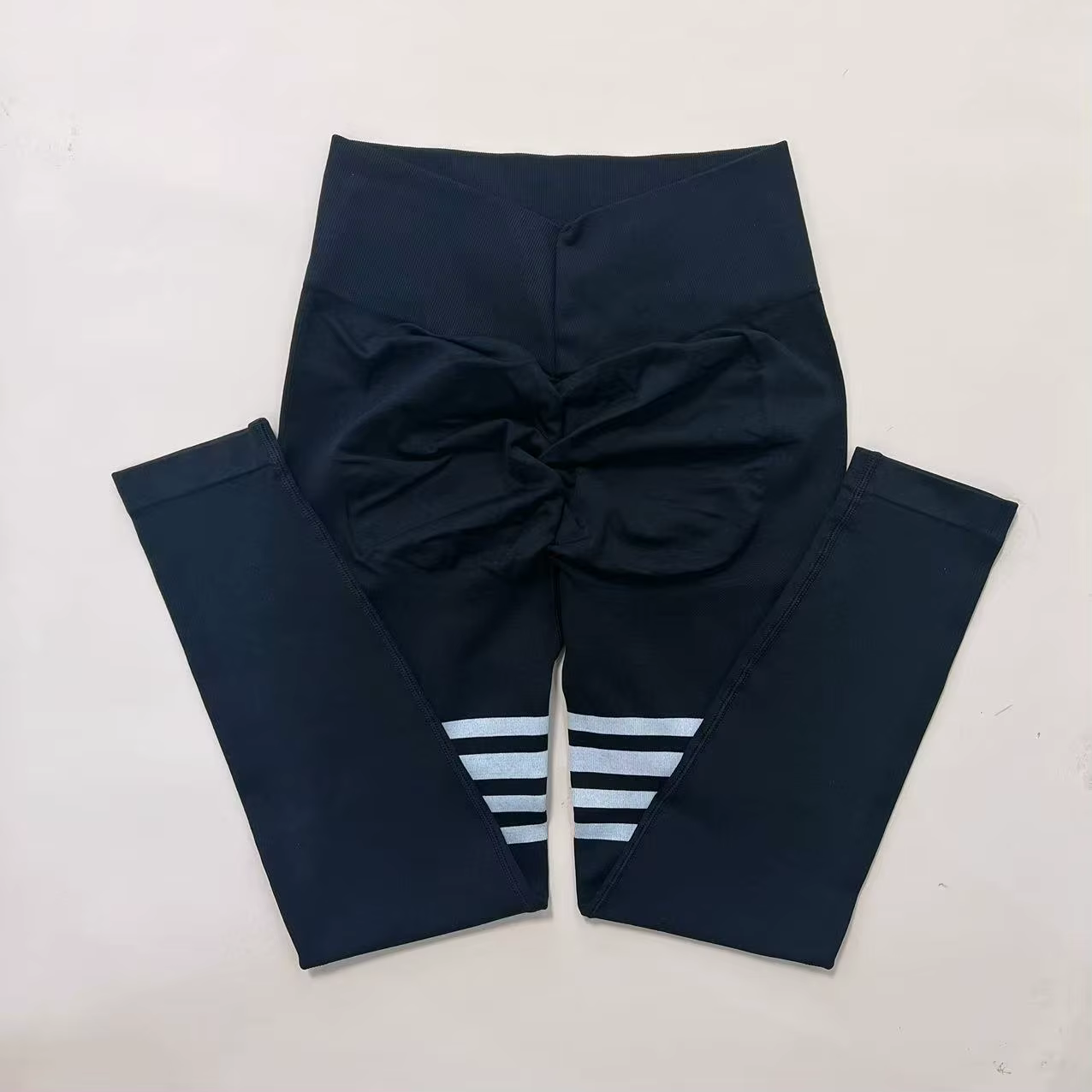 Women’s striped high-waist compression leggings with stylish back bow detail and sporty stripes on the legs.