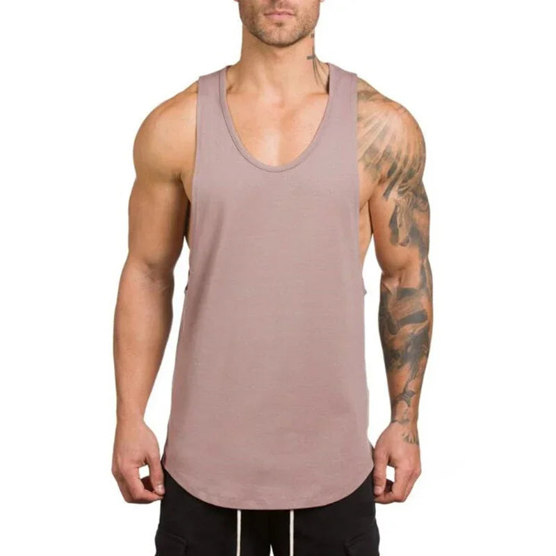 Man wearing a cotton breathable sleeveless t-shirt in a light brown color, perfect for workouts and outdoor activities.