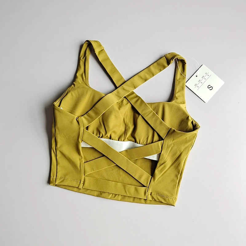 Seamless push-up sports bra for women in mustard yellow with stylish crossover straps and supportive design.