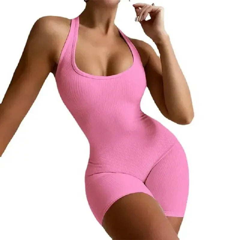 Model showcases a pink backless sleeveless workout bodysuit jumpsuit, designed for movement and style.