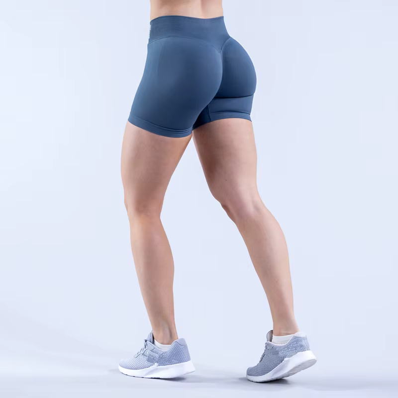 Back view of a person wearing blue Gym Impact Running Shorts with athletic shoes, showcasing fit and style for workouts.