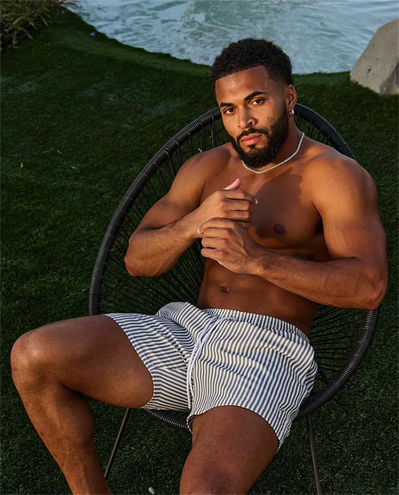 Man relaxing in striped shorts, showcasing stylish outdoor casual wear for summer adventures.