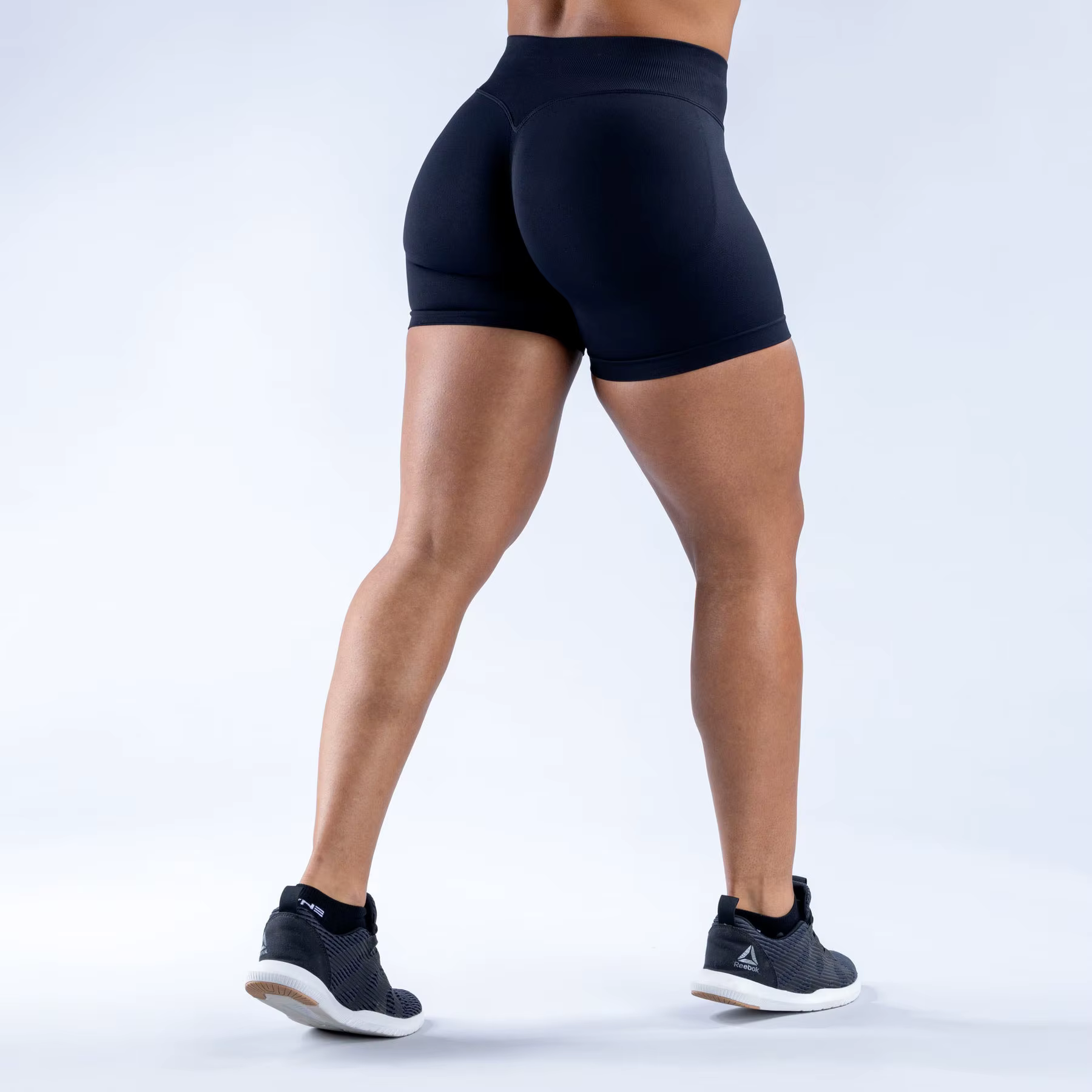 Female model wearing black Gym Impact Running Shorts, showcasing high-performance fit and style for workouts.