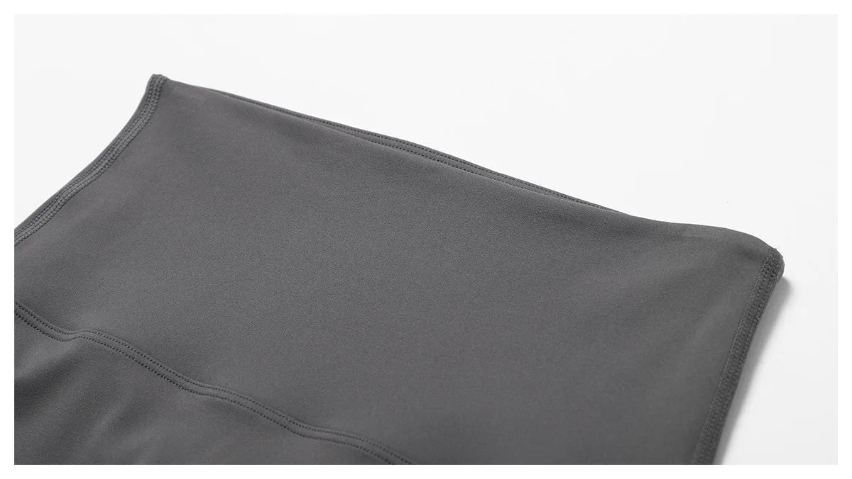 Close-up of the elastic high waistband of high-waist scrunch butt yoga leggings in a sleek gray color.
