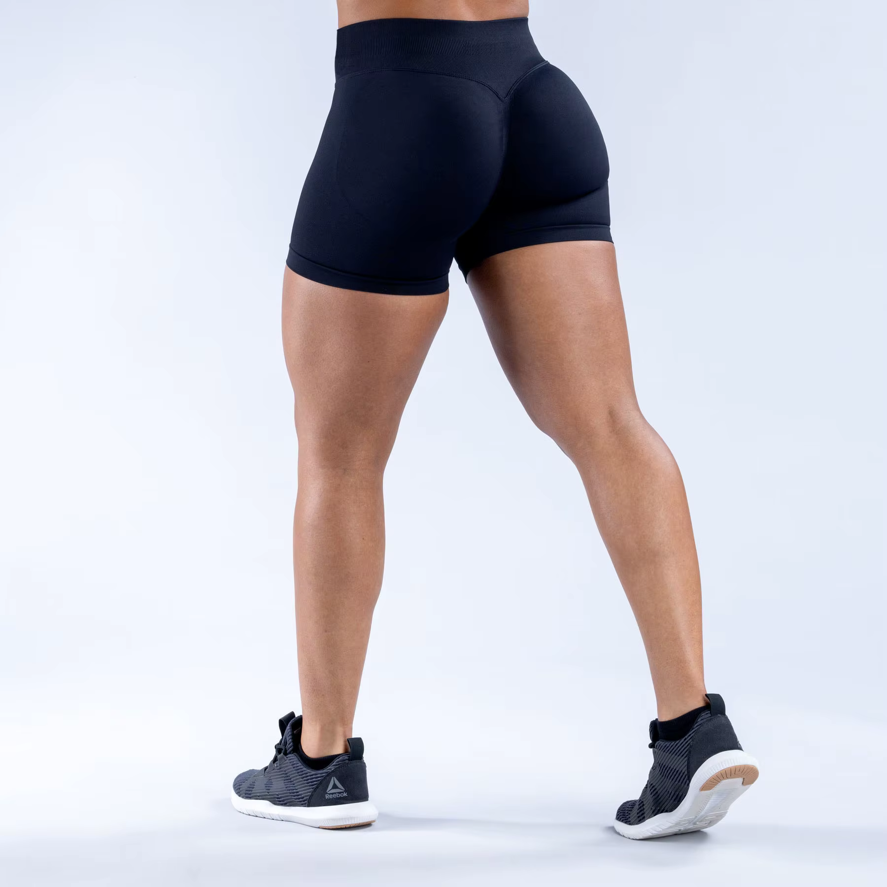 Model wearing black Gym Impact Running Shorts showcasing flexibility and style for workouts.