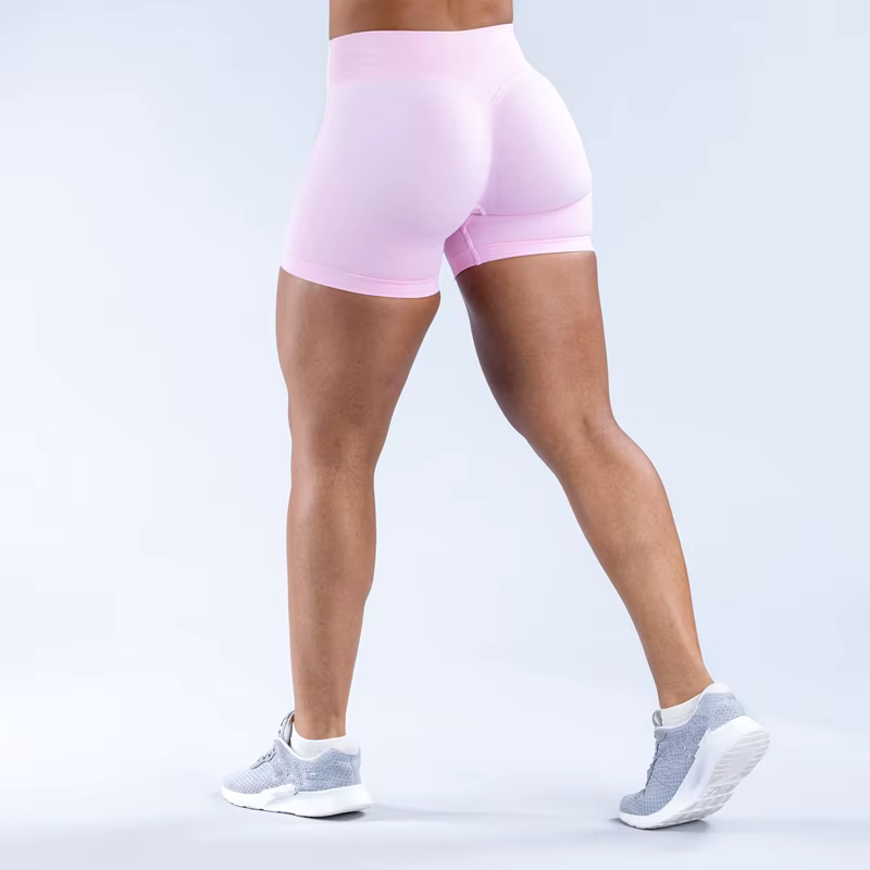 Woman wearing pink Gym Impact Running Shorts showcasing form-fitting design and athletic style.