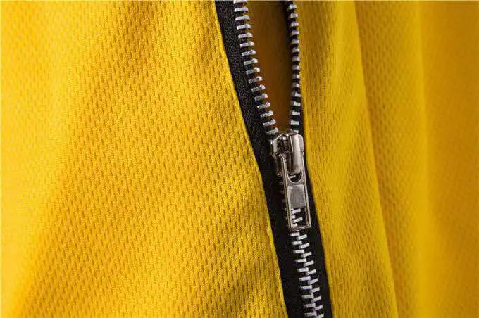 Close-up of yellow mesh basketball shorts featuring a zipper detail for improved functionality and style.