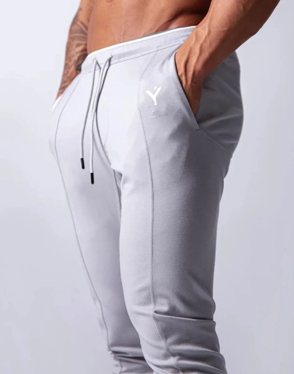 Men's performance training pants in light gray, showcasing comfort, style, and functionality for workouts.