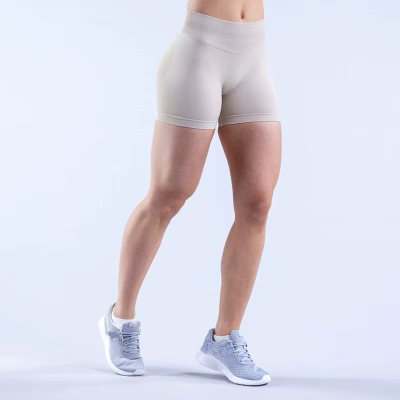 Model wearing beige Gym Impact Running Shorts, showcasing flexibility and style for active workouts and runs.