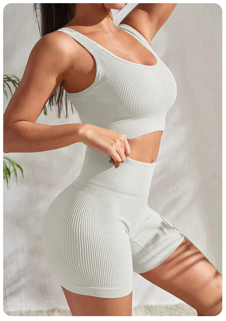 Women’s seamless ribbed yoga set featuring crop tank and high-waisted shorts in light green.