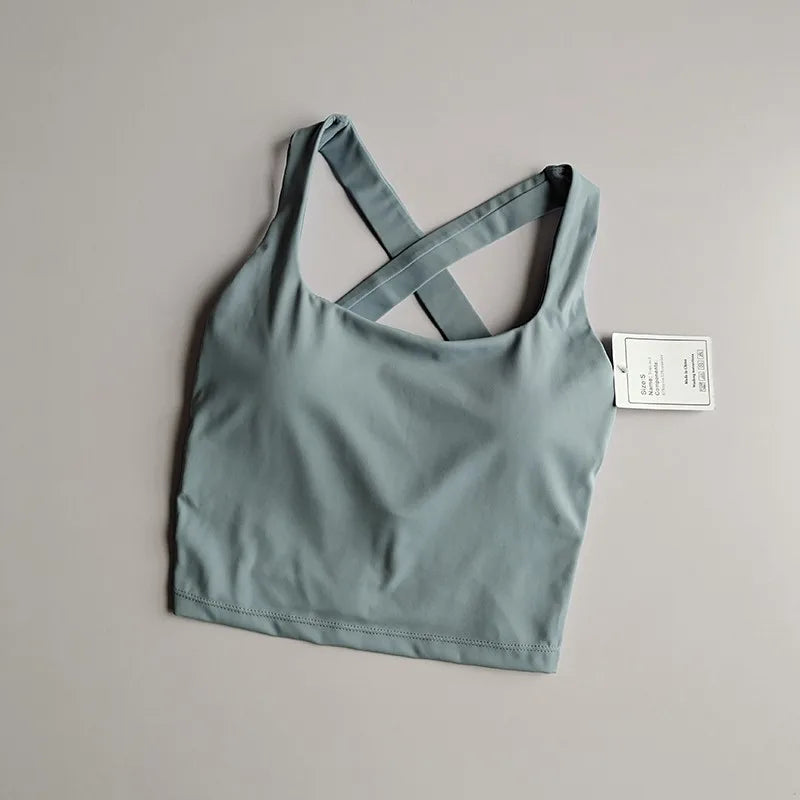 Seamless push-up sports bra for women in soft green with stylish cross-back design, ideal for workouts and yoga.