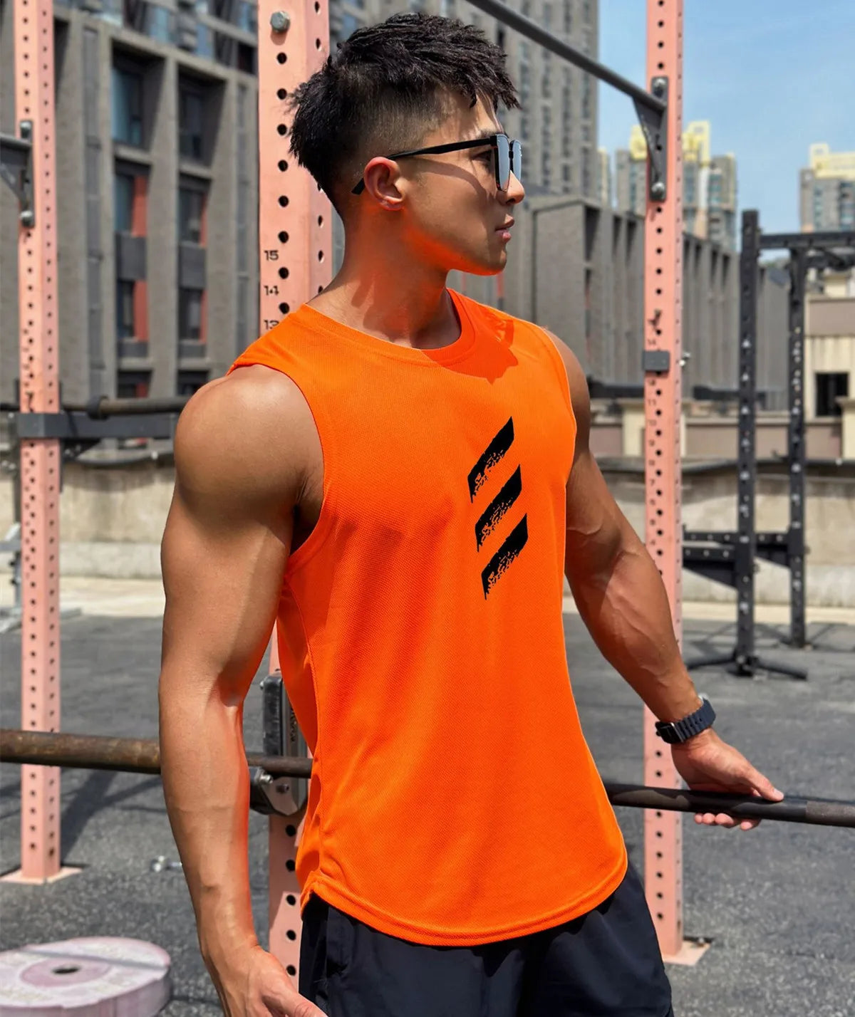 Men's orange sleeveless gym tank top on a muscular model, perfect for summer workouts and high-intensity training.
