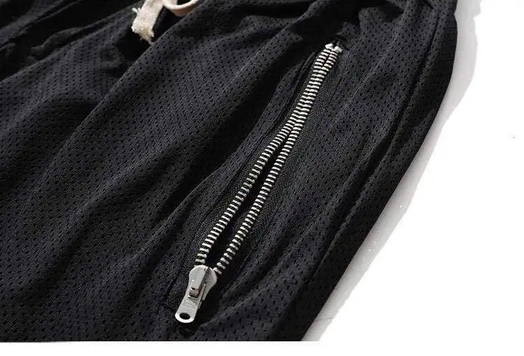 Close-up of black mesh basketball shorts showing breathable fabric and zippered side pocket.