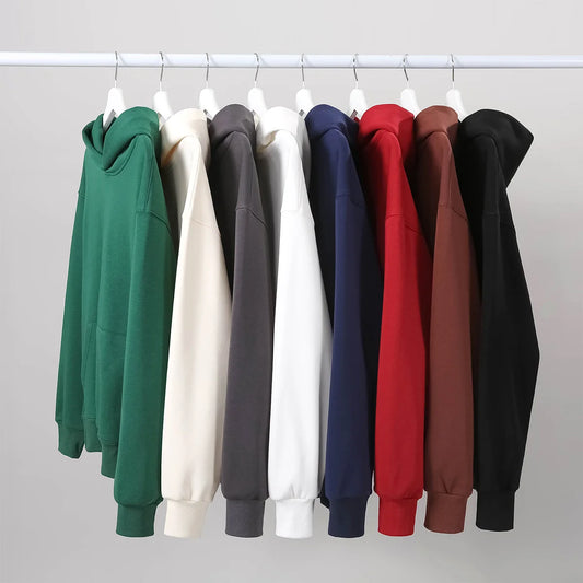 Variety of heavyweight fleece hoodies in different colors hanging on a rack, showcasing warm winter style.