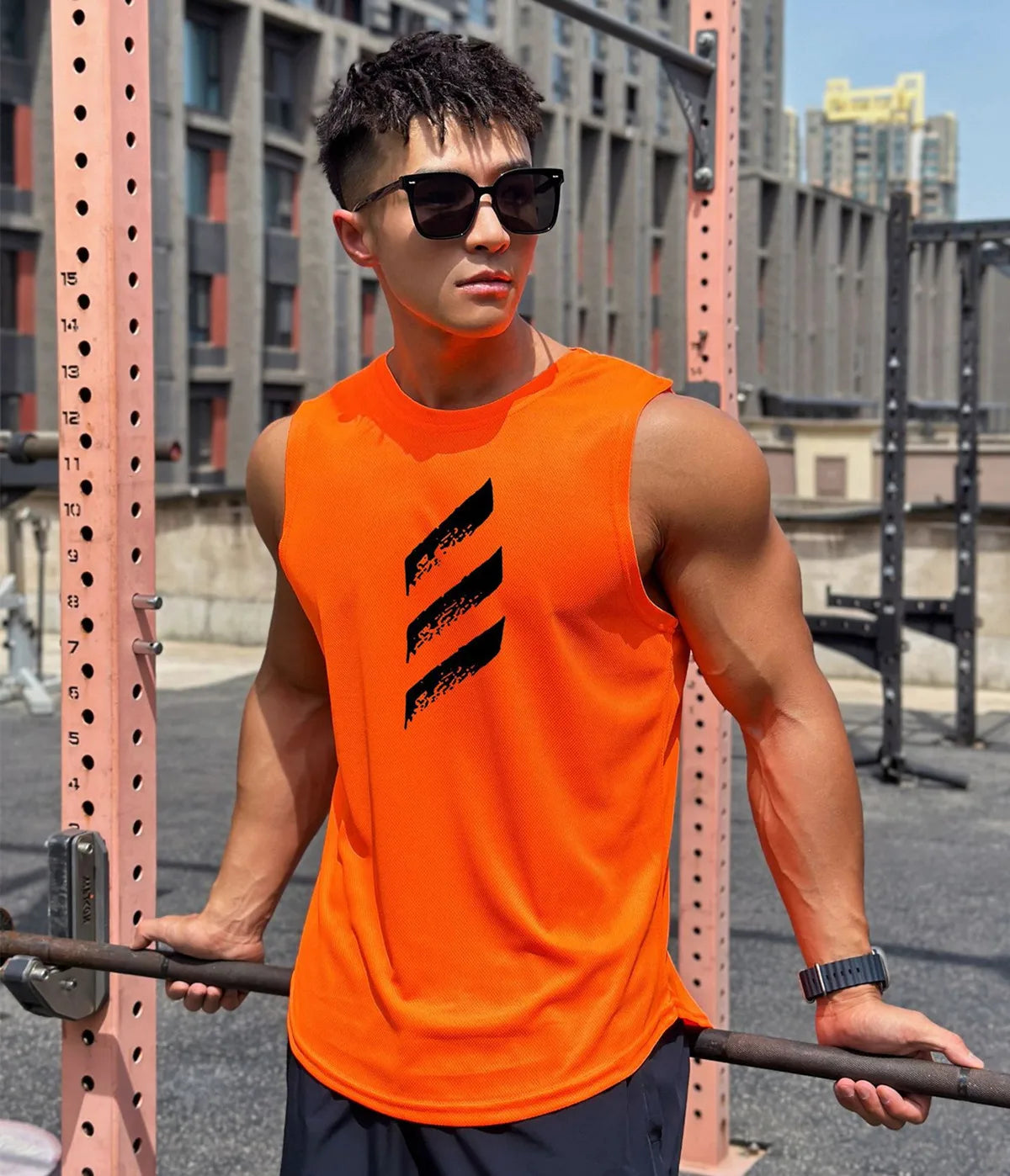 Man wearing an orange sleeveless gym tank top lifting weights outdoors, showcasing style and comfort.
