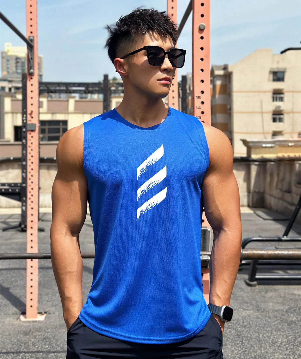 Men's blue quick-dry sleeveless gym tank top modeled outdoors, showcasing style and athleticism.