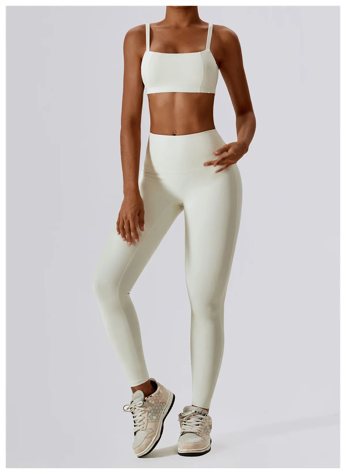High-waist scrunch butt yoga leggings for women in light color, paired with a matching crop top and athletic shoes.