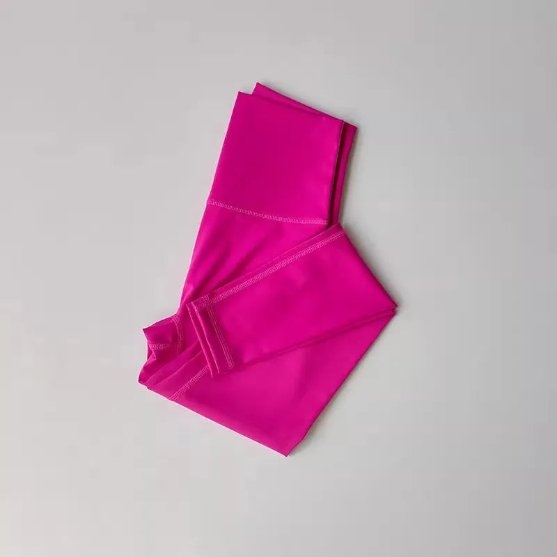 Bright pink high-waisted leggings folded on a white background, ideal for yoga and workouts.