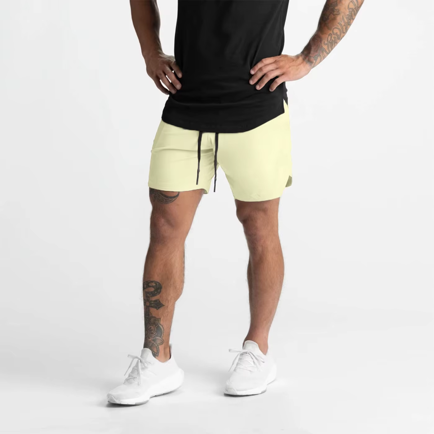 Man in lightweight gym shorts and black shirt poses, showcasing comfort and style for workouts or lounging.