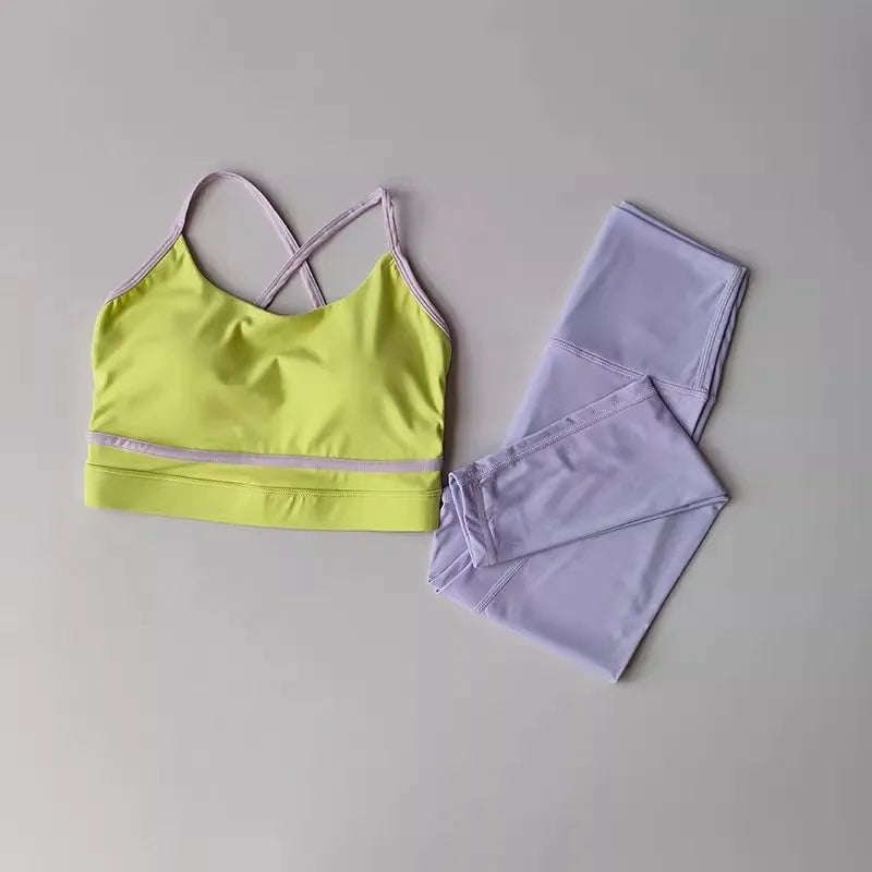 2-piece women's yoga set featuring a green sports bra and lavender high-waisted leggings on a light background.