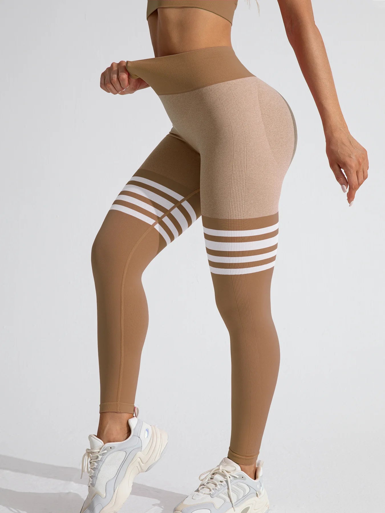 Women’s striped high-waist compression leggings in beige, designed for style and support during workouts.