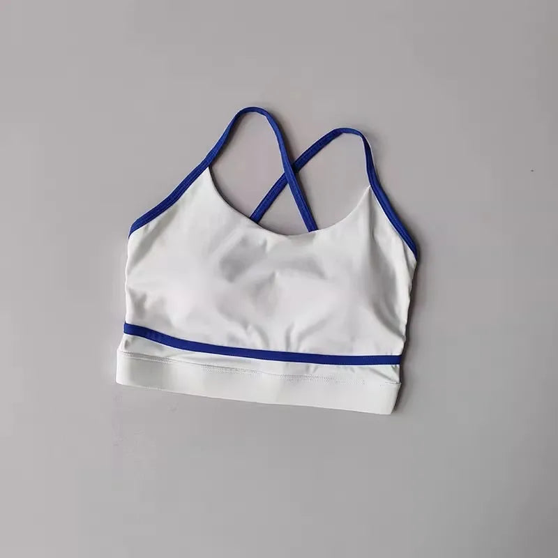 White sports bra with blue trim, featuring a stylish cross-back design for yoga and activewear.