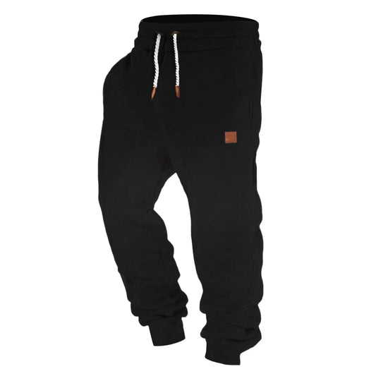 Men's black casual training pants with tapered legs and drawstring, ideal for workouts and daily wear.