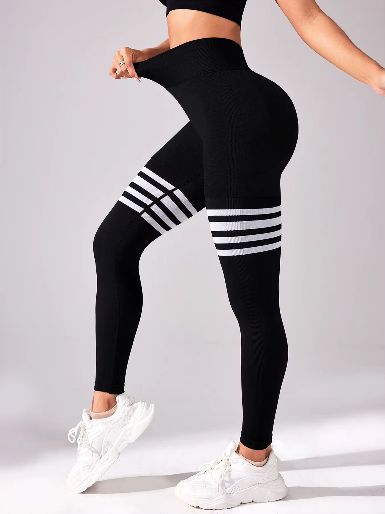 Women's striped high-waist compression leggings, black with white stripes, ideal for workouts and activewear.
