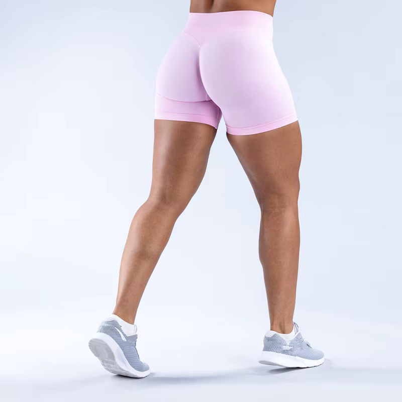 Model wearing pink Gym Impact Running Shorts, showcasing fit and style with breathable fabric and four-way stretch.