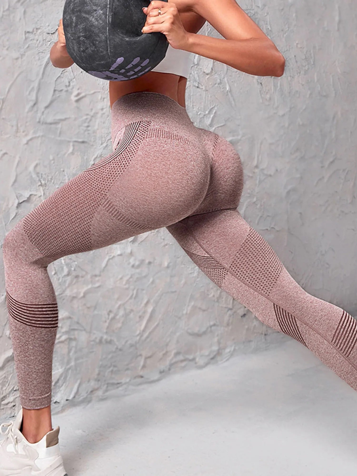 Woman wearing high-waist compression leggings with butt lift technology, showcasing curves during workout.