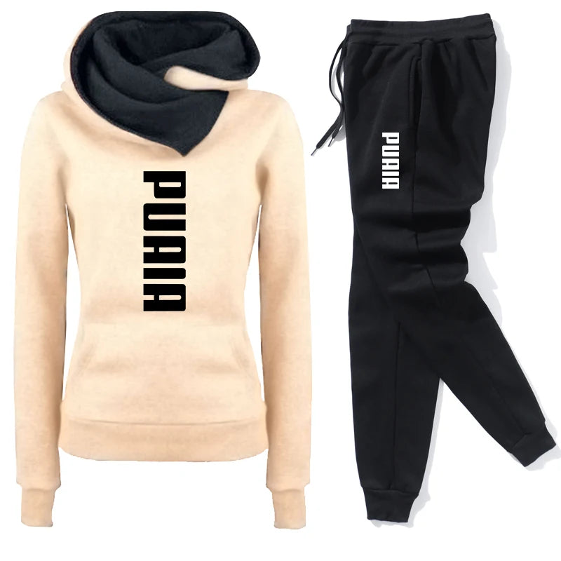 Women's tracksuit featuring a beige hoodie with black logo and matching black sweatpants for comfort and style.