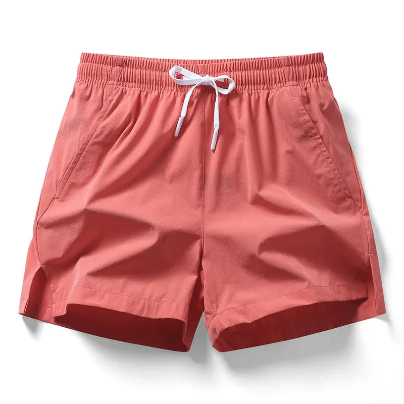 Lightweight coral badminton performance shorts with elastic waistband and side pockets, designed for comfort and agility.