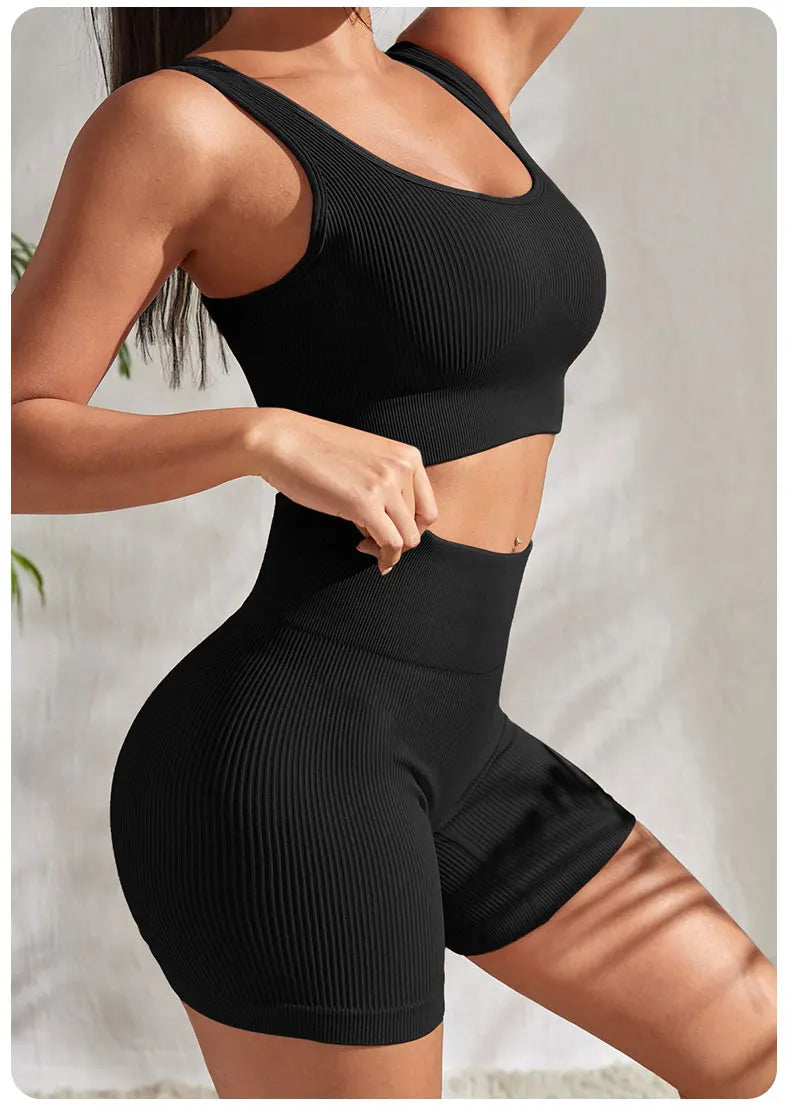 Women’s seamless ribbed yoga set featuring a crop tank and high-waisted shorts in black, designed for fitness and comfort.