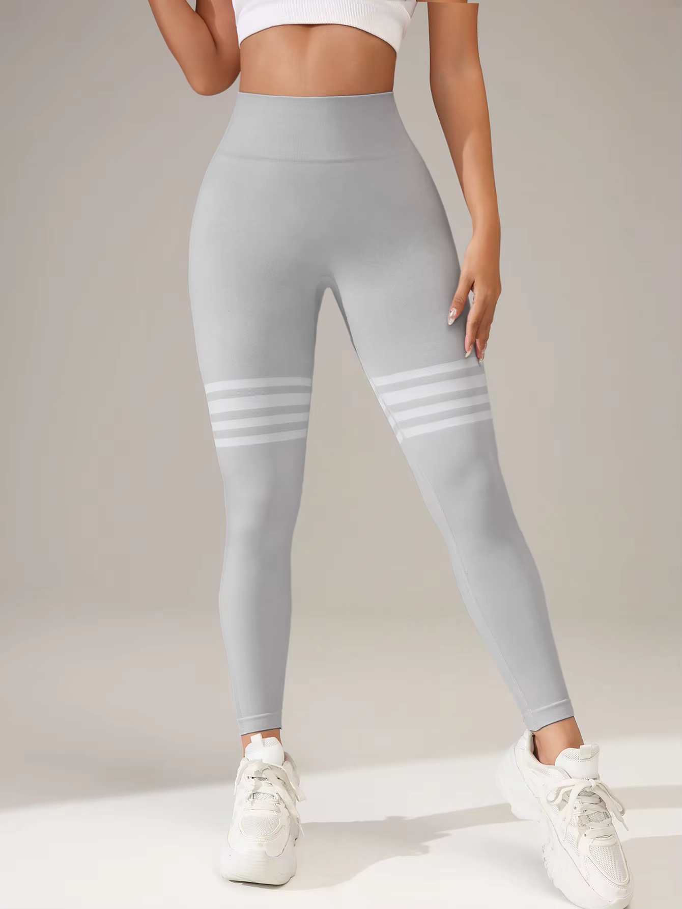Women's high-waist compression leggings in grey with white stripes, perfect for workouts and active days.