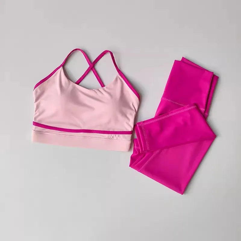 2-piece women's yoga set featuring a light pink sports bra with crisscross straps and bright pink high-waisted leggings.