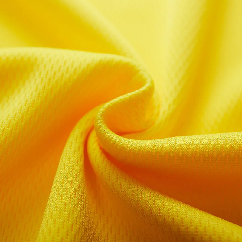 Close-up of breathable yellow polyester fabric, ideal for sportswear and quick-dry clothing.