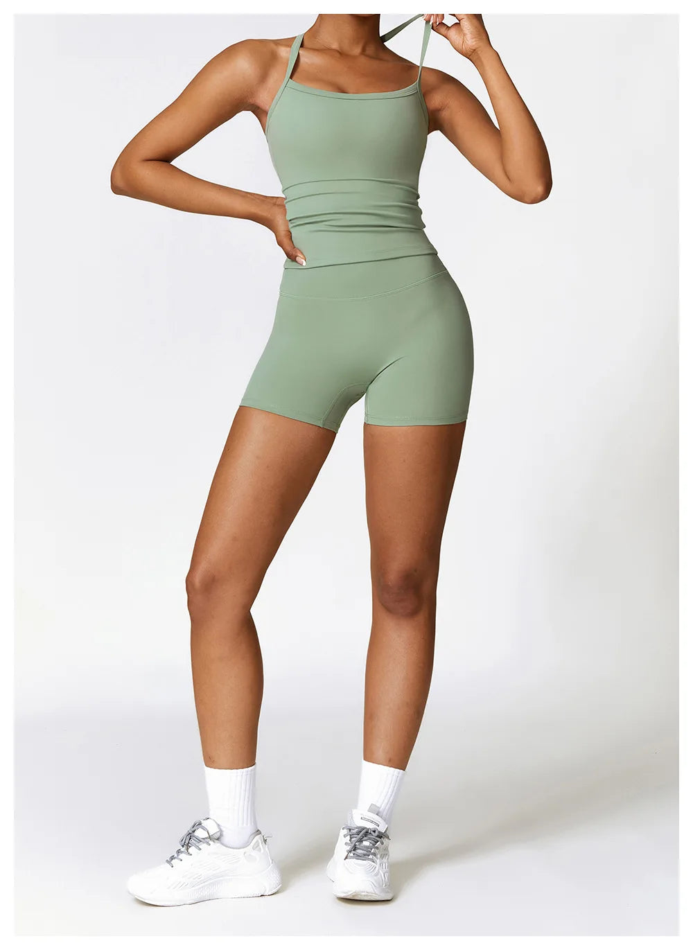 Model wearing a light green crop top and shorts, showcasing athletic wear for sports and workouts.
