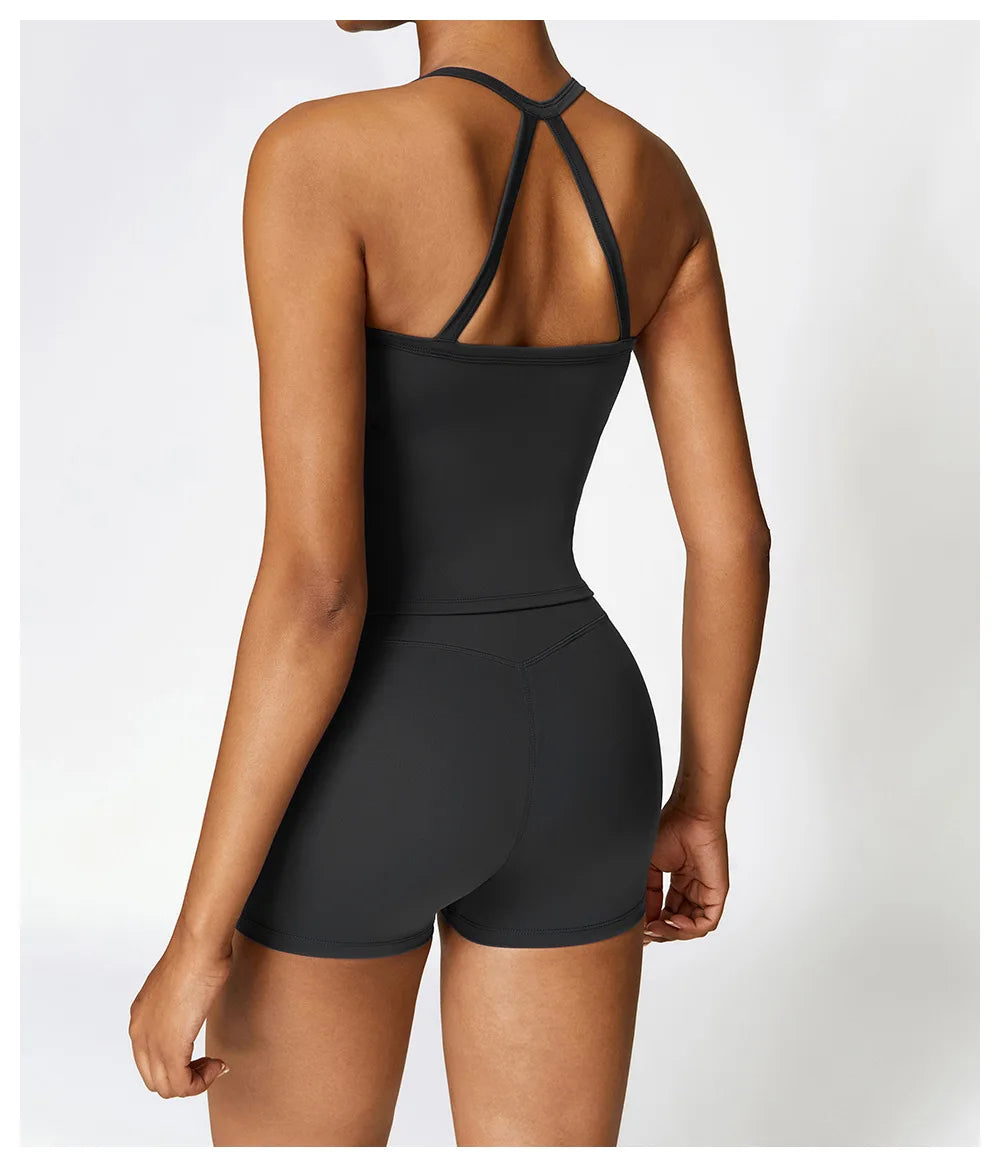 Model showcasing a black Cross Back Push-Up Sports Bra with wide straps and shorts from the back, highlighting style and support.